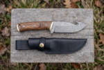Vermillion Coil Damascus gut hook hunting knife with rosewood handle, brass bolster and black leather sheath on barn wood