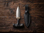 Blackhorn high carbon push dagger with polished buffalo horn T-handle and black leather sheath on dark wood