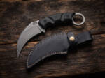 Shadowstone stonewashed D2 karambit knife with black Micarta handle and black leather sheath on dark wood