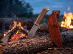 Firebrand Walnut satin spring steel cowboy bull cutter knife with walnut handle, brass bolsters and tooled leather sheath by a campfire