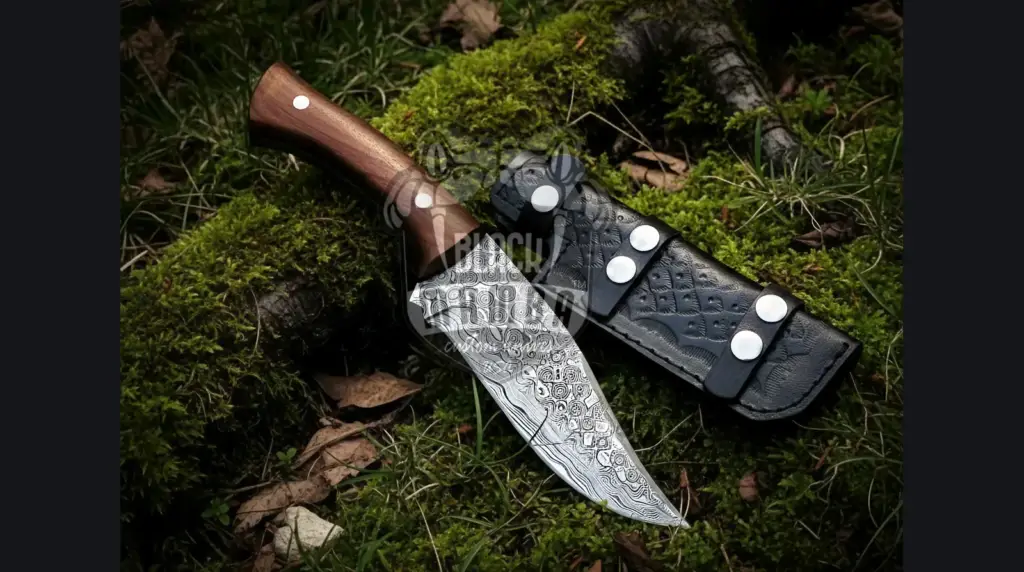 Damascus bushcraft knife in a split log beside a campfire at dusk