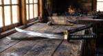 Onyx Crane handmade Damascus katana with high polish 28 inch curved blade, black silk ito over white rayskin, blackened iron tsuba and brass habaki in a forge