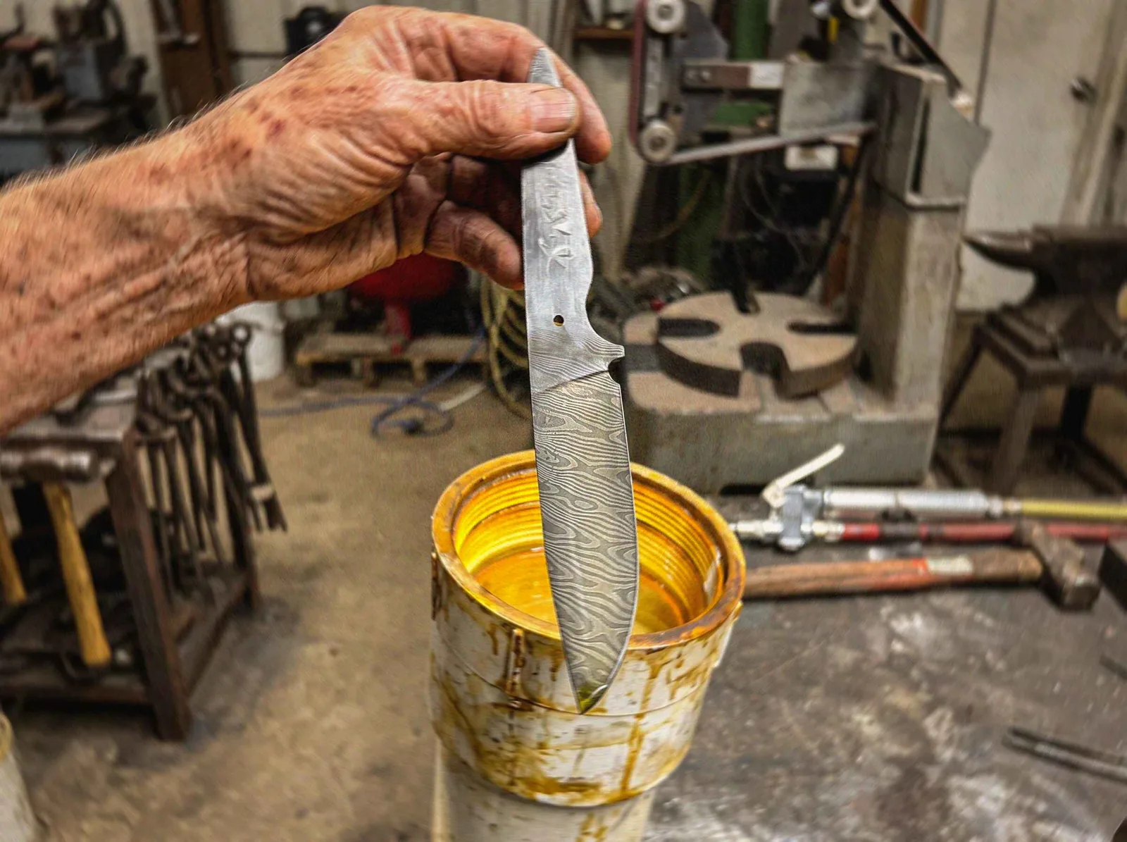 Etching a hand-forged Damascus blade in acid to bring out the pattern in the folded steel