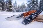 Tiger Amber mirror polished D2 steel Tom Brown style tracker knife with orange and brown tiger micarta handle in snow