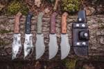 Set of five handmade D2 steel Tom Brown style tracker knives with rosewood, black micarta, military green micarta, burgundy micarta and walnut handles, with black leather tracker sheath