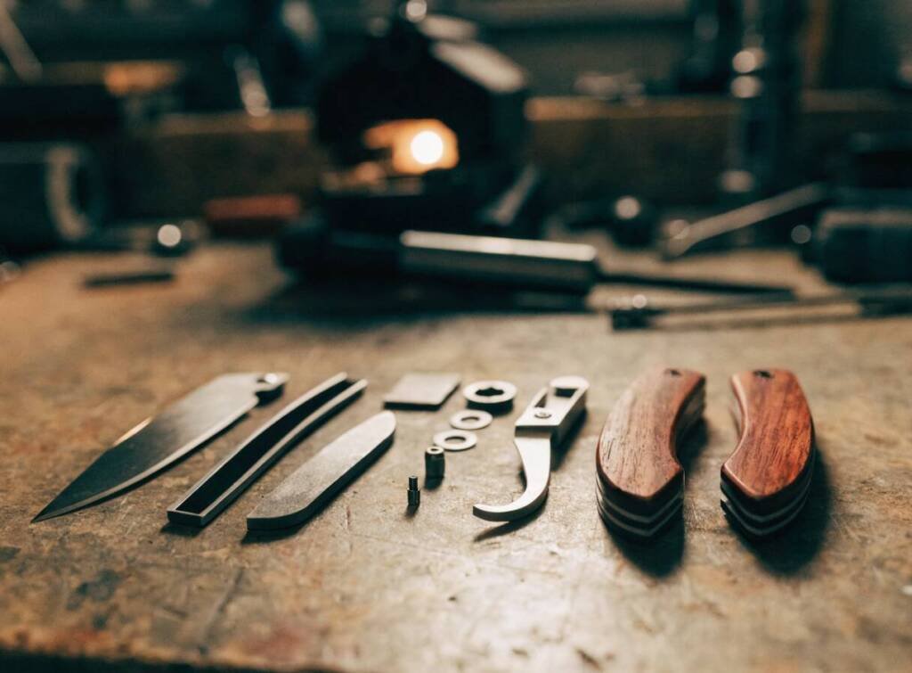 Folding pocket knife parts laid out in order before assembly